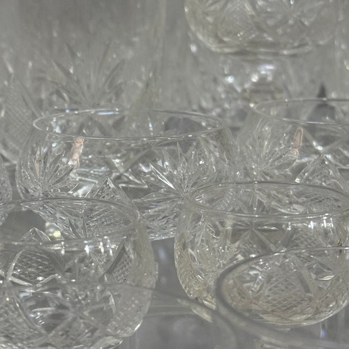 27 - A suite of cut table glass comprising 12 Champagne coupes, eleven smaller coupes, seven ports, six l... 