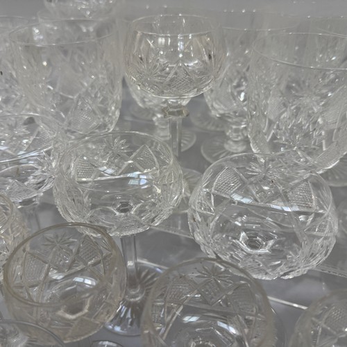 27 - A suite of cut table glass comprising 12 Champagne coupes, eleven smaller coupes, seven ports, six l... 