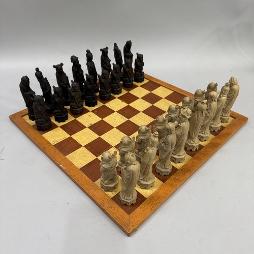 77 - A resin chess set in the form of Chinese figures together with a games board