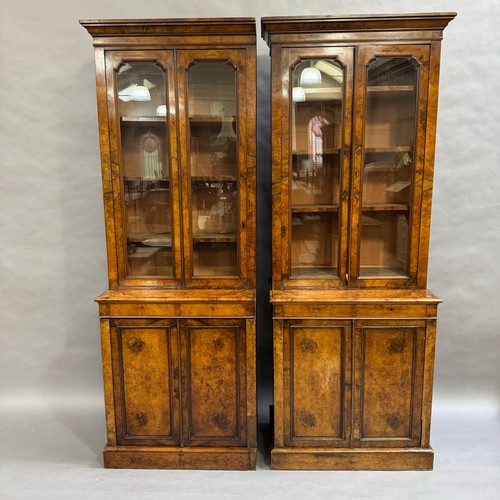 316 - A pair of walnut two door bookcases, two doors below with revealing filing drawers, the sides having... 