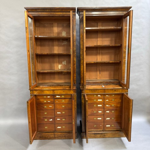 316 - A pair of walnut two door bookcases, two doors below with revealing filing drawers, the sides having... 