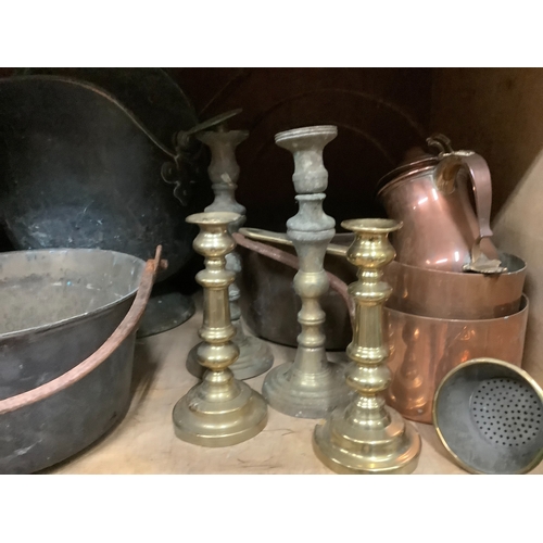 100 - A large collection of brass and copper items to include jam pans, trivets, coal helmets, candlestick... 