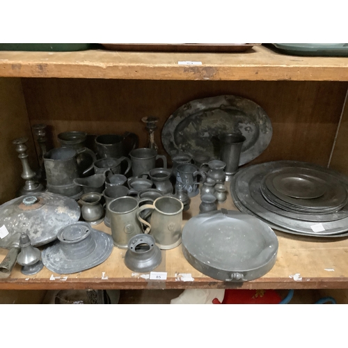 85 - A large quantity of pewter plates, measuring jugs, cups, candlesticks, bed pan, ink well, salt and p... 