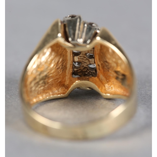 212 - A DIAMOND RING c.1970, the brilliant cut stones claw set in two off set rows flanked by broad convex... 