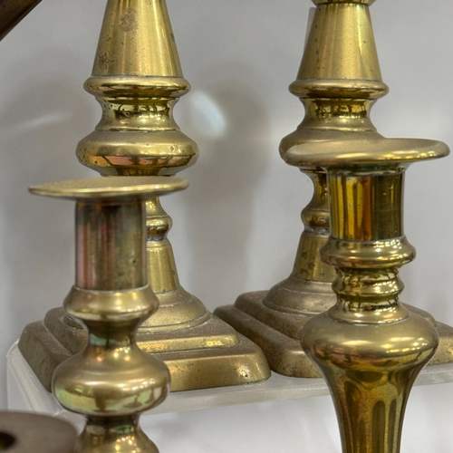 205 - An antique copper Dutch whale oil lamp, a pair of Victorian brass pricket candlesticks on rectangula... 