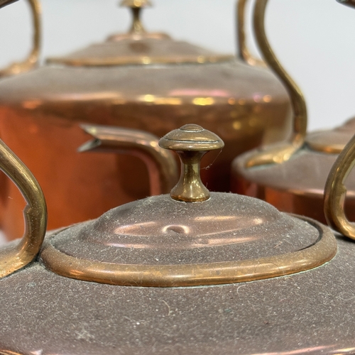 197 - Three copper kettles of graduated size and similar oval design 28cm, 21cm and 19cm  high over handle