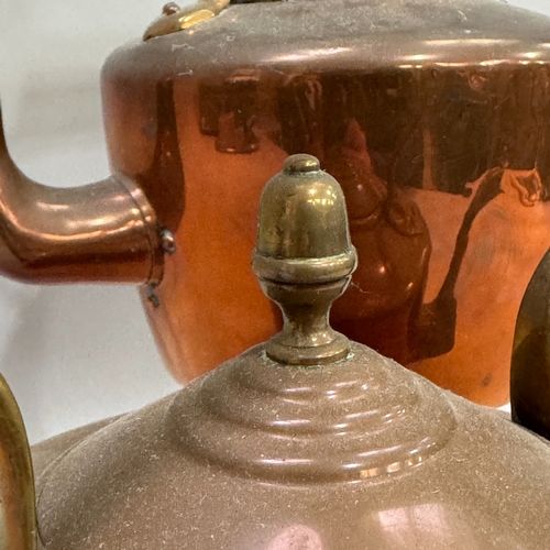 218 - A close pair of copper kettles with acorn finials to the domed lids, 27cm high over handle