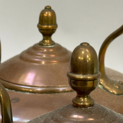 218 - A close pair of copper kettles with acorn finials to the domed lids, 27cm high over handle