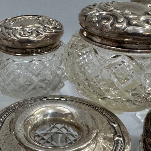 238 - Seven cut glass and silver lidded toilet jars, hair tidy, open salt and bottle c1910