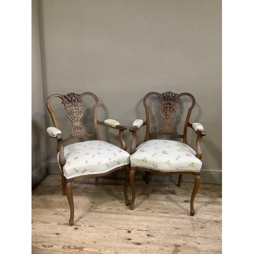 157 - A pair of continental style walnut open framed salon chairs with carved and pierced back upholstered... 