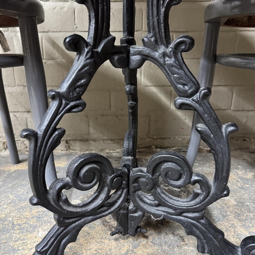 152 - A cast iron bar/kitchen table with circular granite top together with two grey painted bentwood chai... 