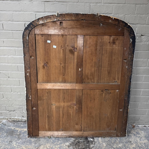 153 - An black painted over mantel mirror of arched profile, 136cm high x 113cm