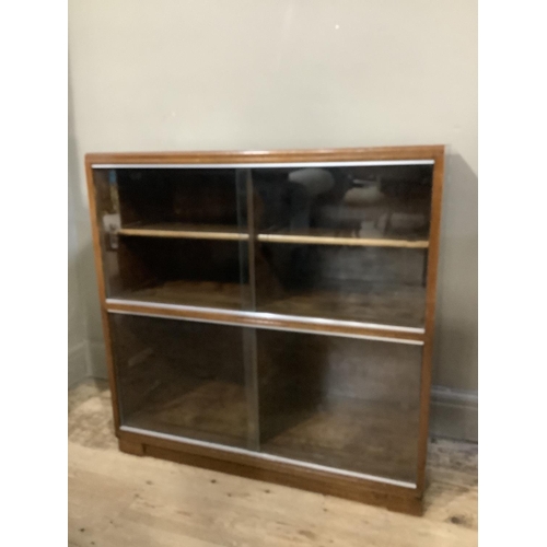 298 - A mahogany two section Minty bookcase with glazed sliding doors, plinth base