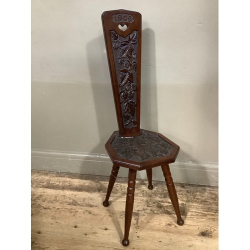 305 - A mahogany carved spinning chair on turned legs, carved 1909 to back with carved foliage to back and... 