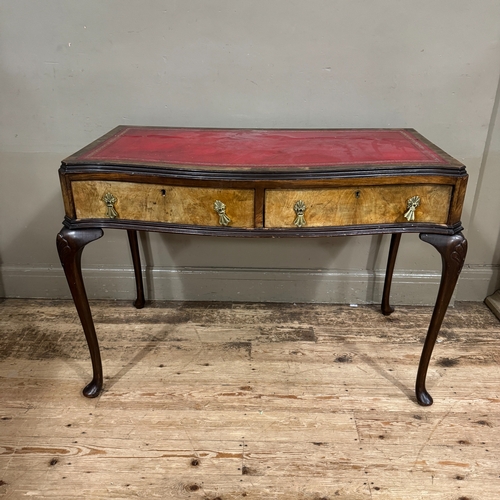 309 - A 1950s serpentine fronted walnut writing desk, two drawers , incised red leather writing surface, c... 