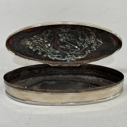 237 - A silver trinket box of oval outline, the lid embossed with the head and shoulders of a girl wearing... 