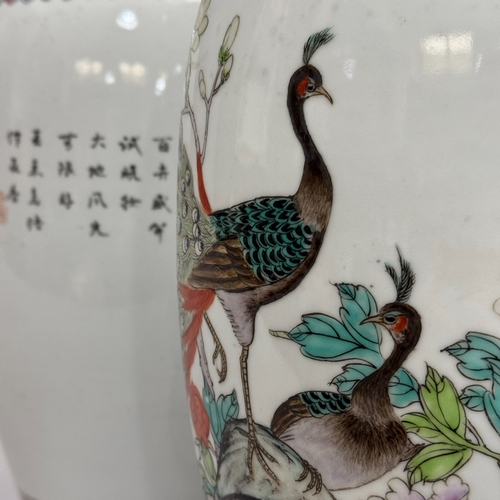 67 - A pair of reproduction Chinese famille rose table lamps painted with peacocks perched on rocks issui... 