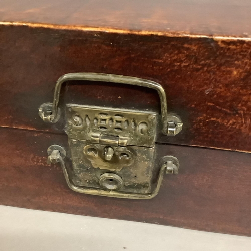 79 - A wooden leather-bound Chinese trunk with metal mounts, twin handles to front clasp, with label to i... 