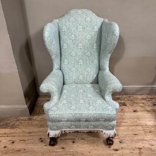 359 - A Georgian style winged armchair with arched back, cut back arms and on cabriole legs with claw and ... 