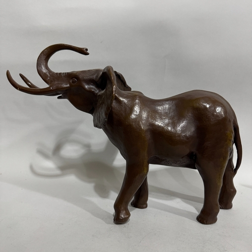 83 - A modern bronze model of an elephant, its trunk raised and ears wide, 57cm long x 41cm high, fractur... 