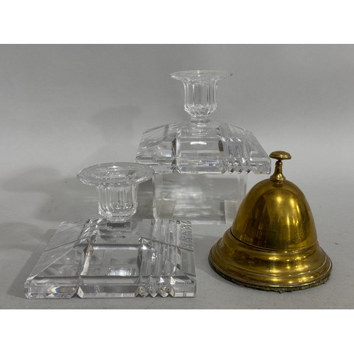 81 - A pair of cut glass candlesticks, having flat rims and faceted sockets, on a square canted bases cut... 