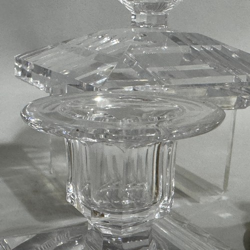 81 - A pair of cut glass candlesticks, having flat rims and faceted sockets, on a square canted bases cut... 