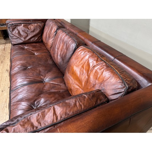 374 - A dark tan/brown leather three seater sofa with loose back and side cushions, 230cm x 98cm