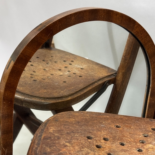 337 - An early 20th century child's folding chair together with a mahogany toilet mirror of arched outline... 