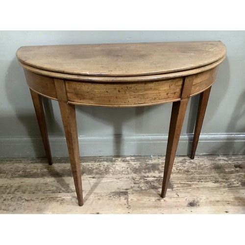 351 - An early 19th century fold over demi-lune tea table on square tapered legs