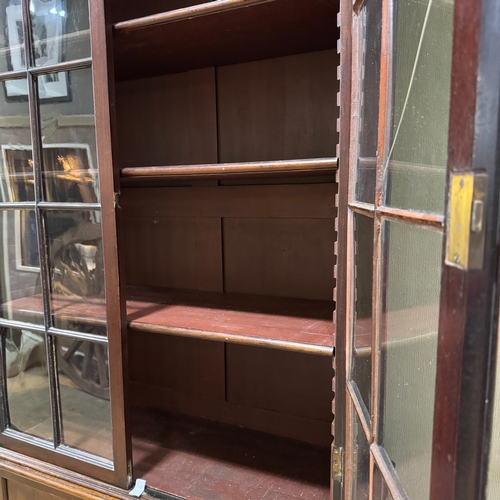 363 - A mahogany bookcase having two glazed doors above two door cupboard below, associated top and bottom