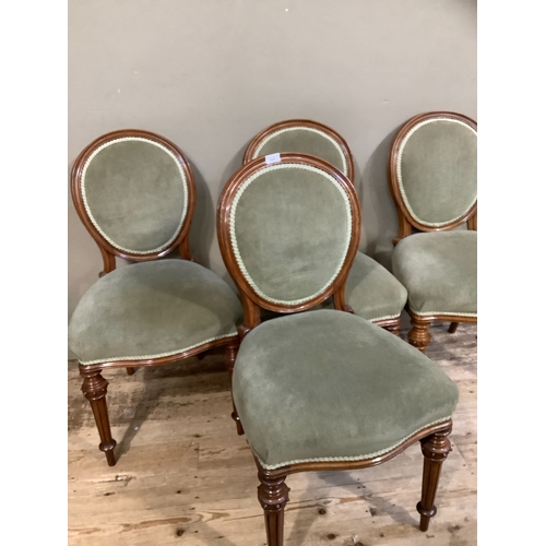 366 - A set of four Victorian walnut dining chairs having encircling frame to the oval back, upholstered b... 