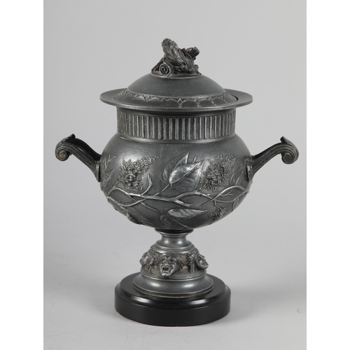 64 - A LATE 19TH CENTURY PEWTER TWO-HANDLED URN AND DOMED COVER with laurel wreath finial, reeded rim abo... 