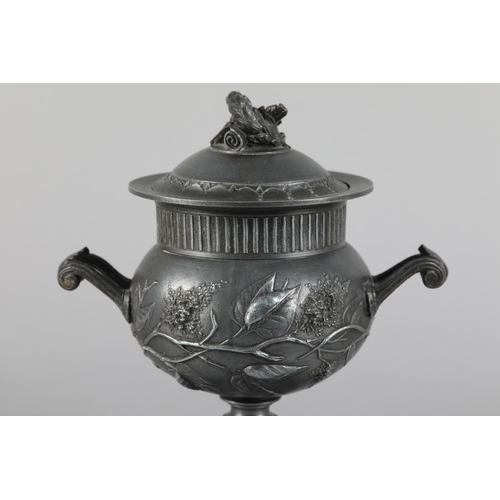 64 - A LATE 19TH CENTURY PEWTER TWO-HANDLED URN AND DOMED COVER with laurel wreath finial, reeded rim abo... 