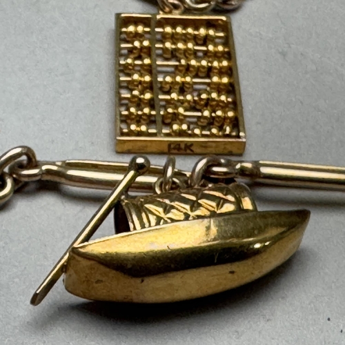 357 - A bracelet in fetter links, hung with two charms, all in yellow metal (tests as 9ct gold), fastened ... 