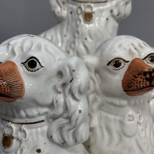 313 - A pair of Victorian Staffordshire spaniels, 31.5cm high, another single spaniel at 31cm high and a f... 