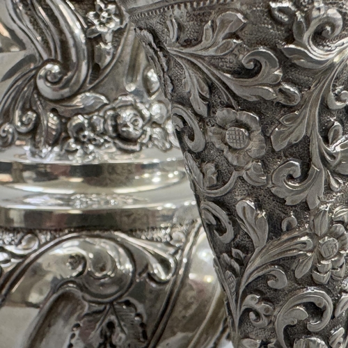 335B - A silver plated sugar caster embossed with C-scrolls and flowers, 21.5cm high, together with a white... 