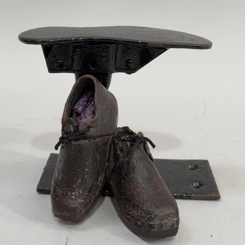 56 - A pair of infant's leather and wood clogs together with a cobbler's child sized last