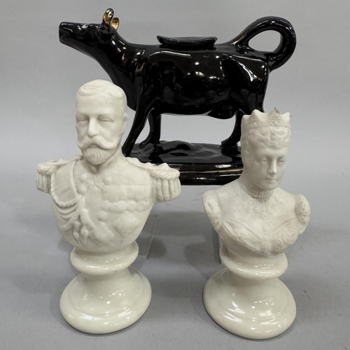 67 - A pair of Parian ware busts of George V and Queen Mary together with a black glazed pottery cow crea... 