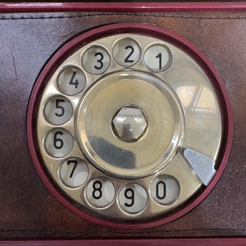 262 - A Telcer phone in a cream box, the console in red plastic with leather surround to the rotary dial a... 