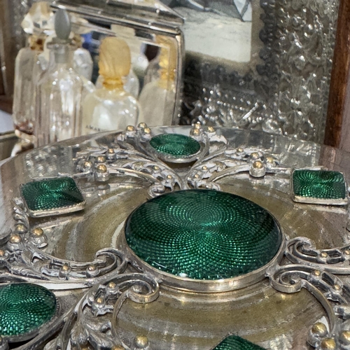 239 - A silver plated and emerald green enamelled lidded glass powder bowl, a gilded copper hand mirror em... 