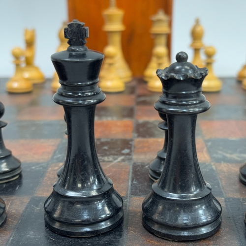 322 - An early 20th century chess set of natural and ebonised boxwood in a wooden case together with a che... 