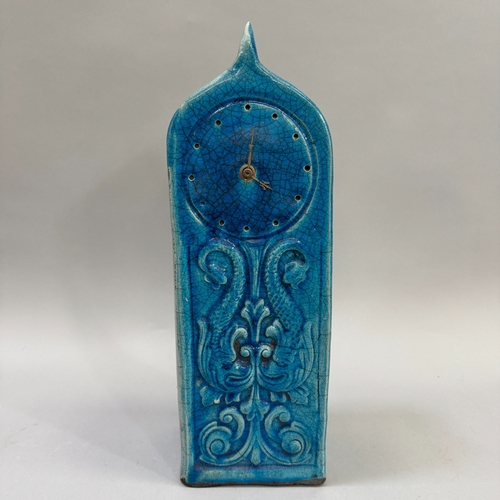 232 - A turquoise crackle-glaze clock, of arched outline, the panel moulded in low relief with opposing do... 