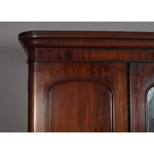 386 - A VICTORIAN MAHOGANY THREE DOOR WARDROBE having a moulded cornice above a mirrored door to the centr... 