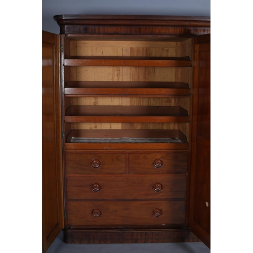 386 - A VICTORIAN MAHOGANY THREE DOOR WARDROBE having a moulded cornice above a mirrored door to the centr... 