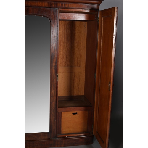 386 - A VICTORIAN MAHOGANY THREE DOOR WARDROBE having a moulded cornice above a mirrored door to the centr... 