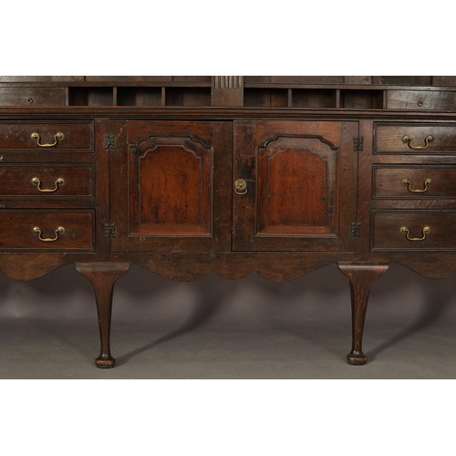 407 - A LARGE GEORGE II STYLE OAK DRESSER AND frieze over a planked back with four shelves, central fluted... 