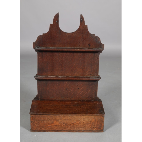 425 - AN EARLY 19TH CENTURY OAK SPOON RACK, having a shaped back with two rails above a box with slope top... 