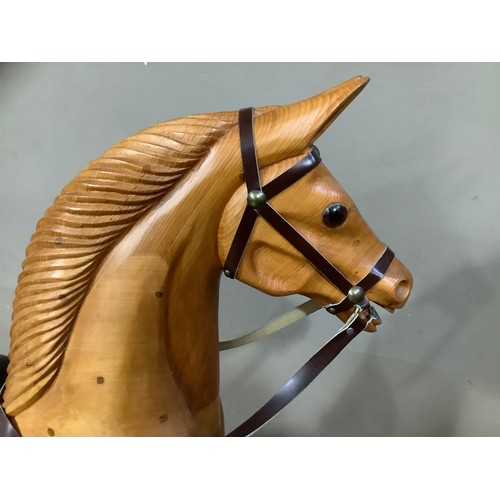 472 - A rocking horse in beech, carved mane, leather reins and saddle and on bow rocker