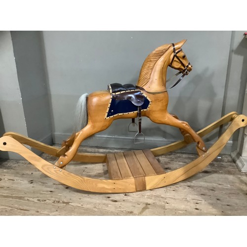 472 - A rocking horse in beech, carved mane, leather reins and saddle and on bow rocker