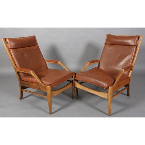 134 - A pair of polished beech and brown leather open armchairs on square tapered legs, c1970